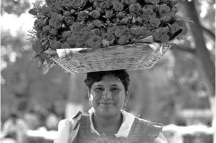 © Peter Langer/EPD Photos A flower vendor wears her inventory on her hat.